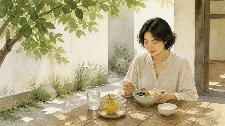 女子坐在树荫下的木桌旁吃一碗果蔬，桌上放着梨和清水
